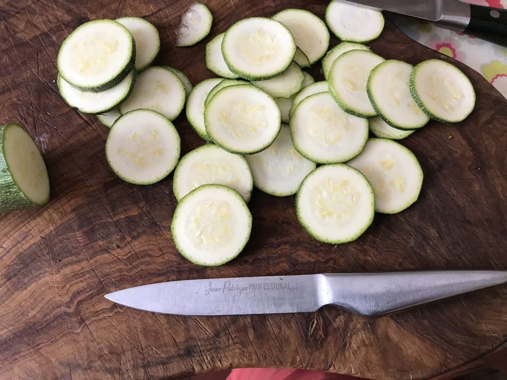 Chopping board with courgette slices and a paring knife.