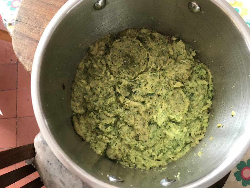 A suacepan with mashed courgettes in it.