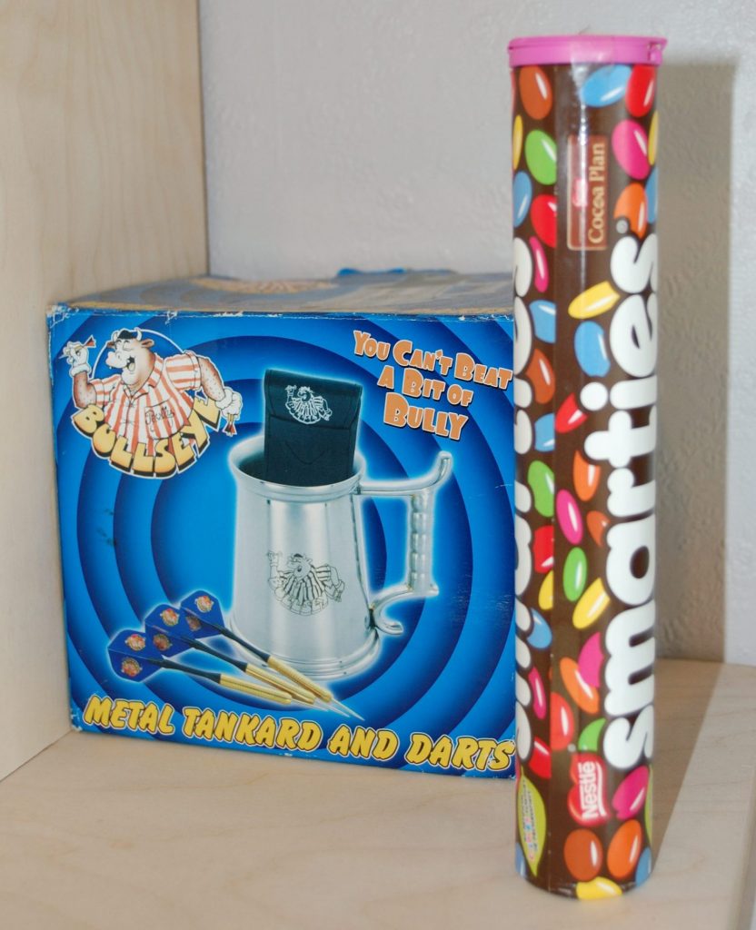 Out of focus tube of smarties in the foreground and Bulleye mug in the background