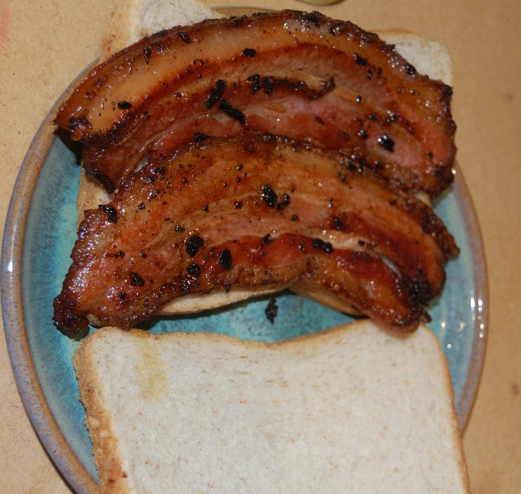 A bacon sandwich with 2 slices of streaky bacon.