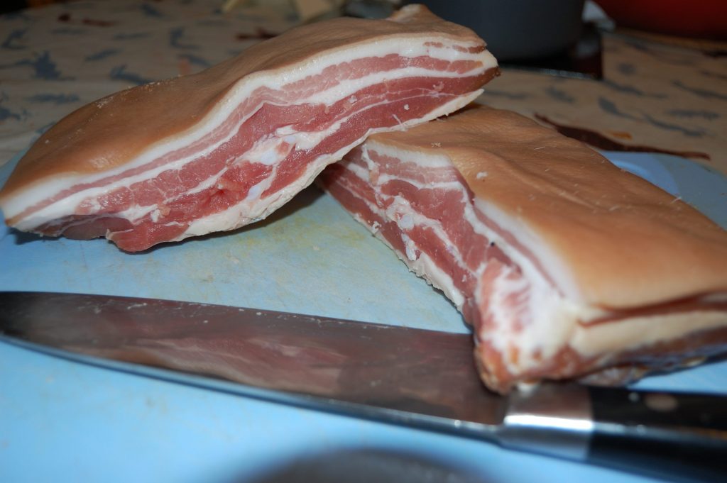 A piece of dry cure bacon that has been cut in half.