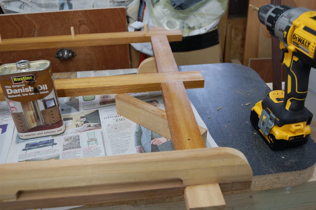 Pan rack with a can of danish oil next to it, half dry and half wet.