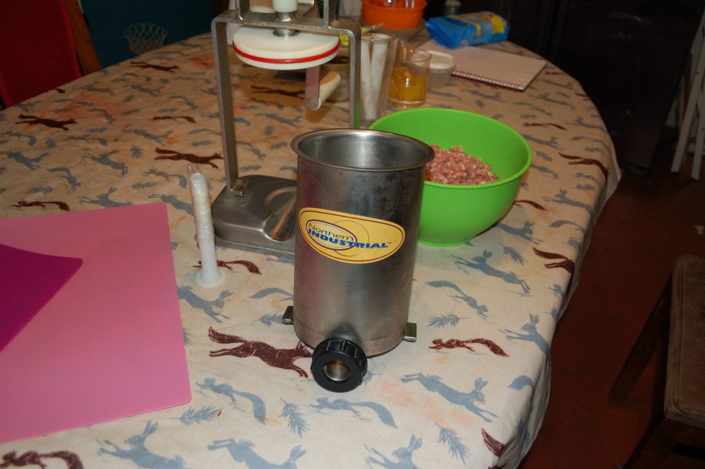 A vertical piston type sausage stuffer.