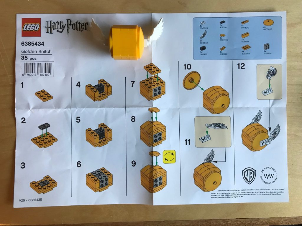 An opened Lego Harry Potter Golden Snitch set all constructed with instructions