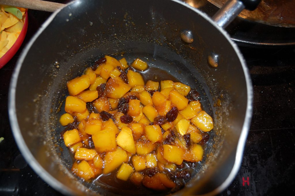 A small pan with cooking sweet pumpkin filling.