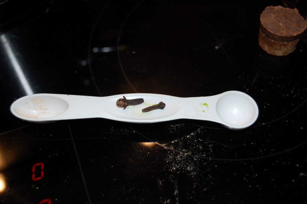 Measuring spoon with 2 cloves on it.