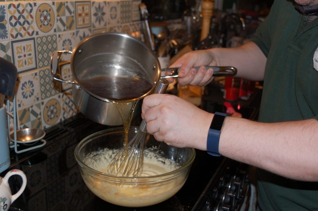 Mixing hot beer with egg and sugar mix.