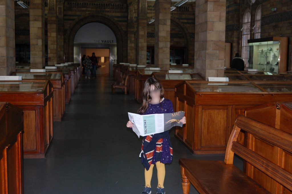 Hoorrid chiild hoolding a map in the Natural History Museum