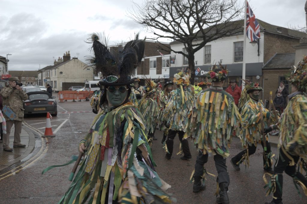 Bourne morris mid routine with a member looking straight at camera